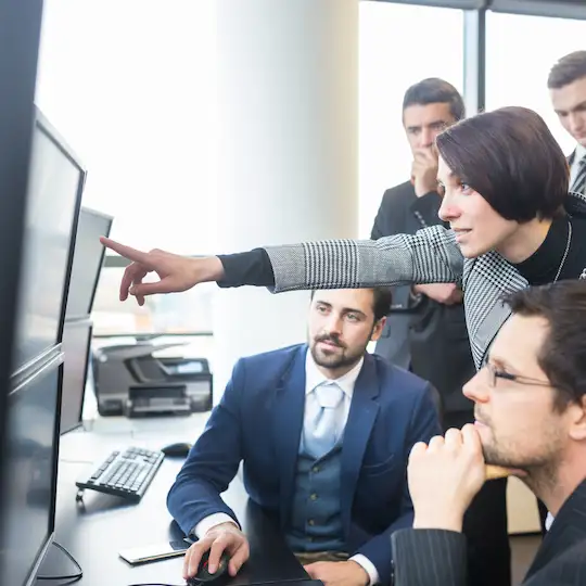 Uma equipe de consultores tributários analisa dados em múltiplas telas, com foco e colaboração, em um ambiente de escritório moderno.